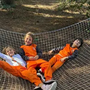 Niños y niñas descansando en una red